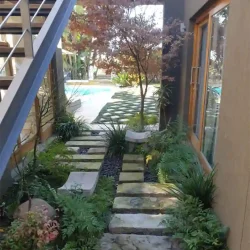 Modern Japanese garden, sandstone slabs as stepping stones in I-Ching patterns, small Zen meditation benches, black pebbles, Japanese Maple tree.