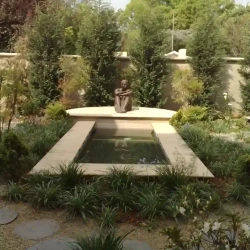 Bronze sculpture of woman overlooking meditation pond. Meditation garden.