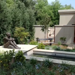 Meditation pond with bronze sculpture of woman, bench.