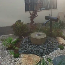 Modern black kakehi water feature with Japanese water basin (tsukubai)