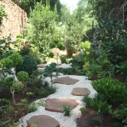 Large Japanese stroll garden. Flat natural rock stepping stones in gravel path.